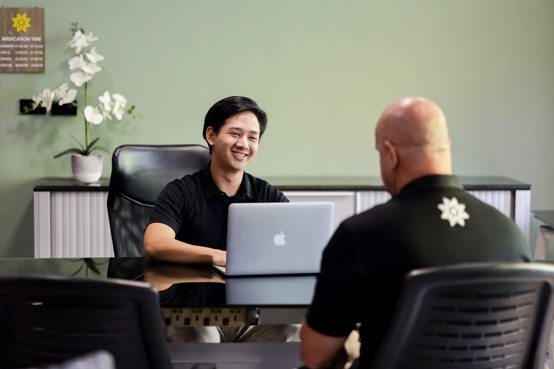 Jintara Rehab staff member discussing the treatment plan and fees with a client in Chiang Mai