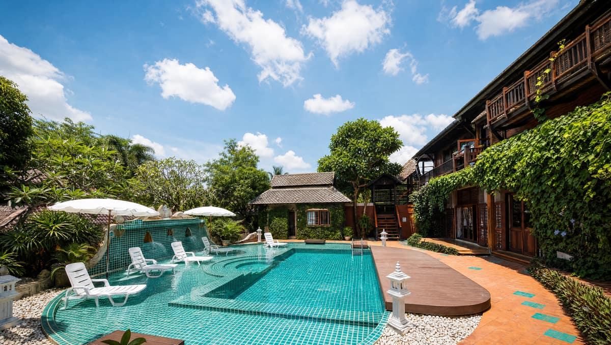 Pool and garden courtyard with Lanna-style buildings at Jintara Rehab Chiang Mai