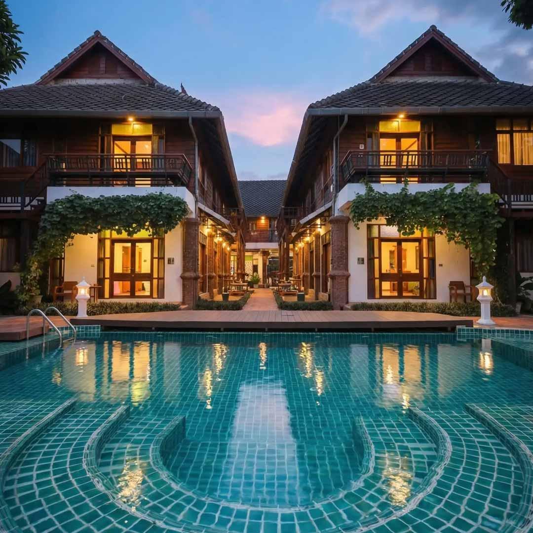 Jintara Rehab pool and Lanna-style buildings at twilight in Chiang Mai