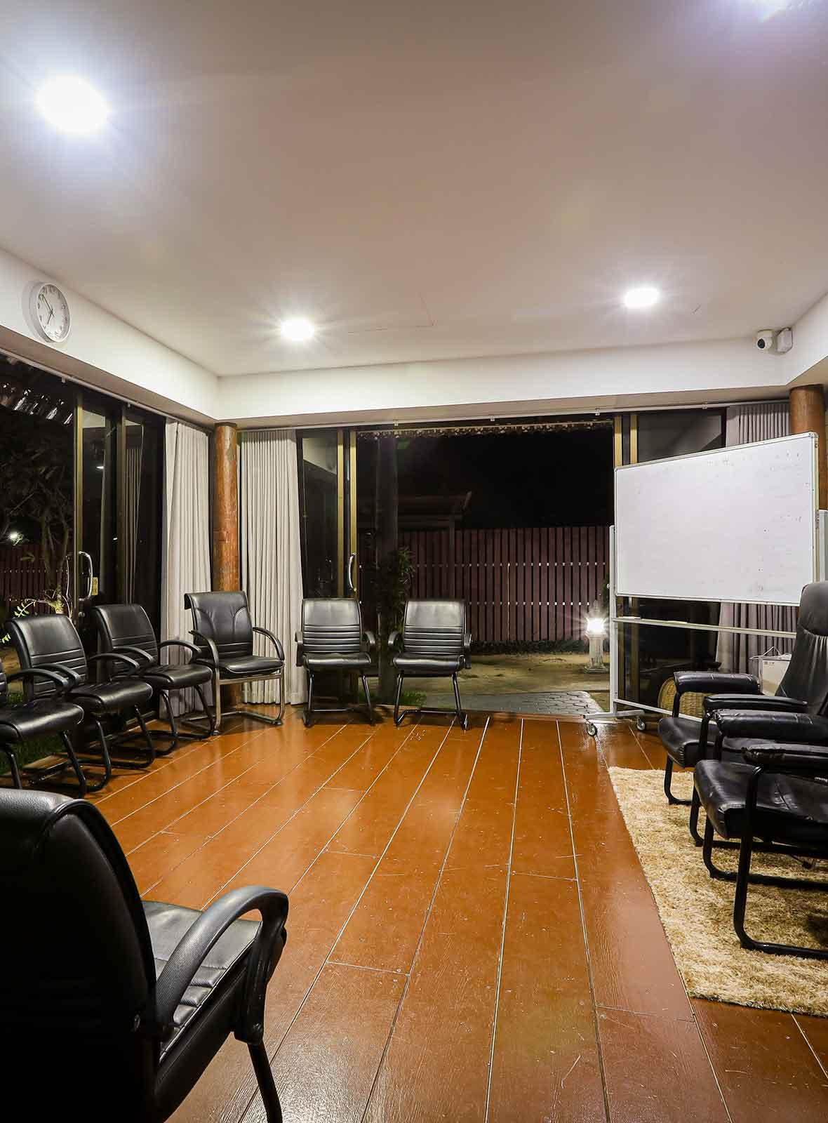 Group therapy room with chairs in a circle and whiteboard at Jintara Rehab Thailand