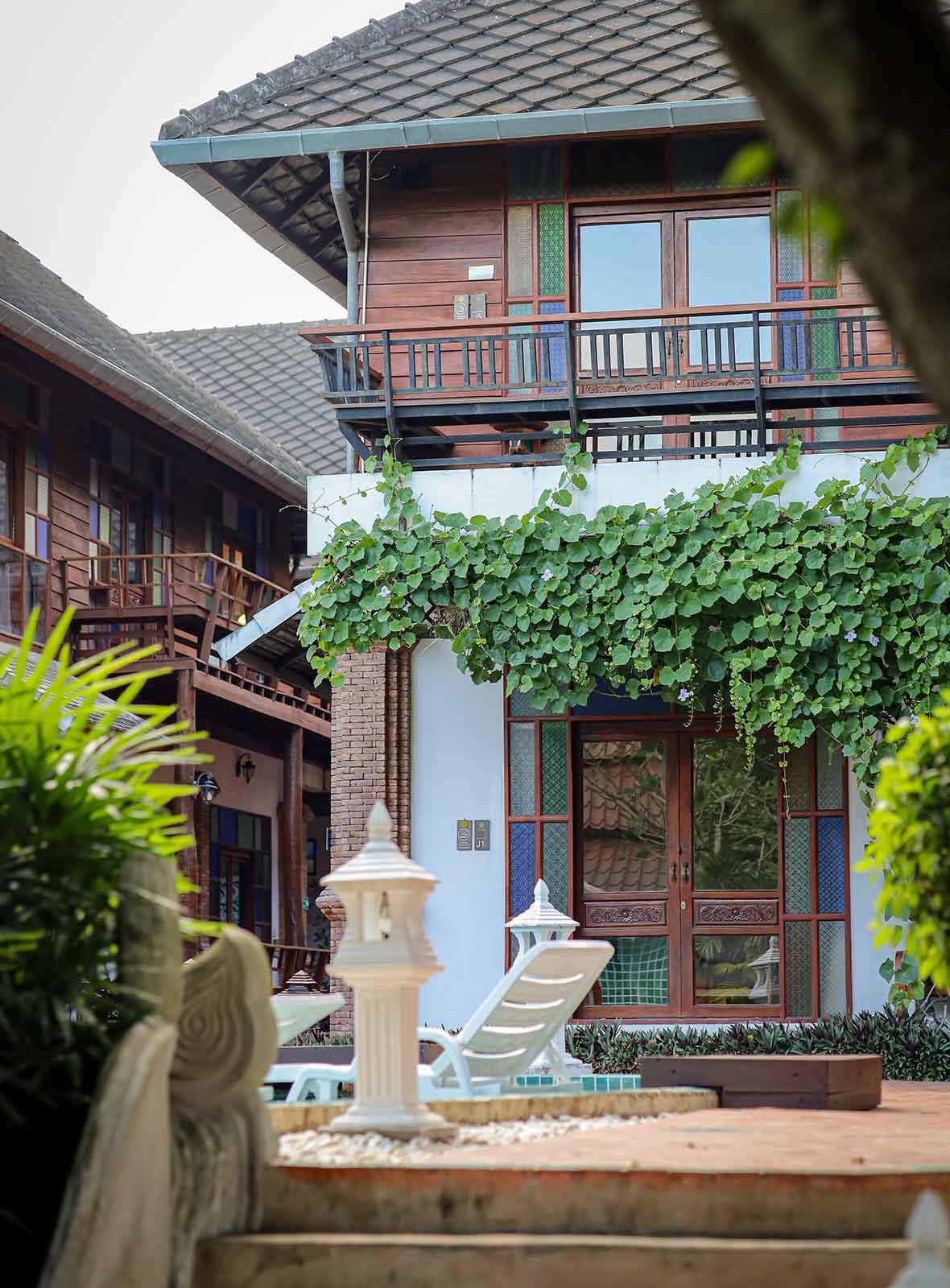 Lanna building with vine-covered walls and balcony at Jintara Rehab Chiang Mai